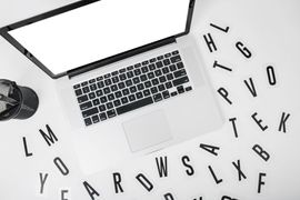 elevated-view-laptop-with-various-alphabets-white-background