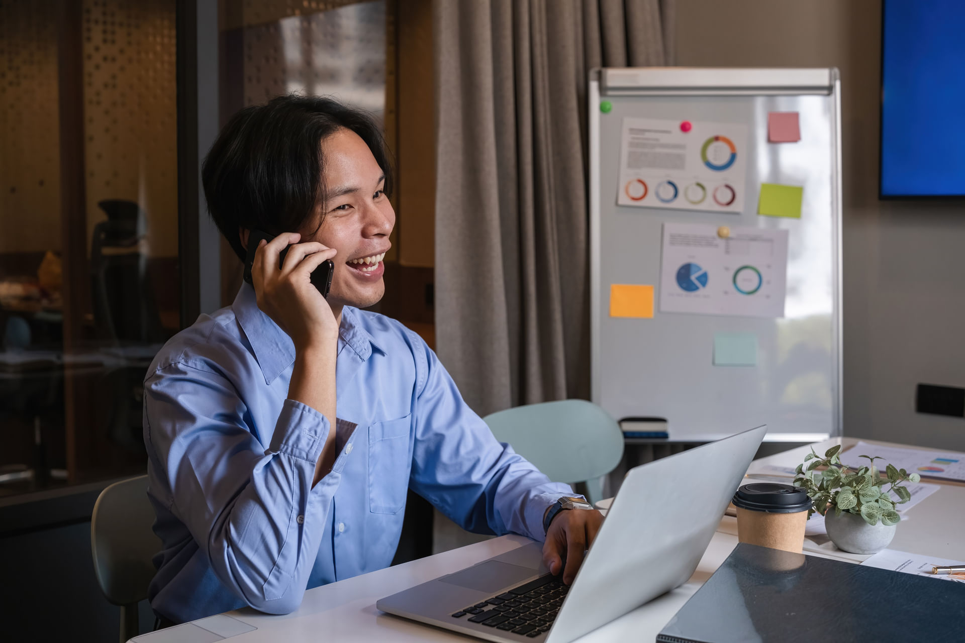 man-using-smartphone-and-laptop-in-office-concept-2024-05-31-20-06-22-utc--1-