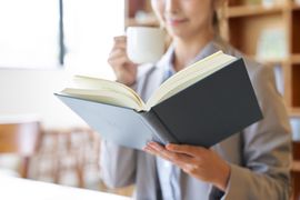 asian-woman-reading-at-a-cafe-2023-11-29-00-13-00-utc--1-