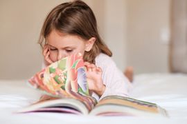 focused-child-girl-reading-book-in-bed-internation-2023-11-27-05-26-15-utc--1-