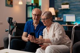 old-man-and-woman-looking-at-smartphone-screen-2023-11-27-04-53-44-utc--1-