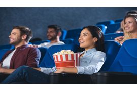 smiling-asian-woman-with-popcorn-watching-movie-in-2023-11-27-04-57-14-utc--1-