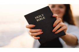 christian-woman-holds-bible-in-her-hands-reading-2023-11-27-05-25-17-utc--2-