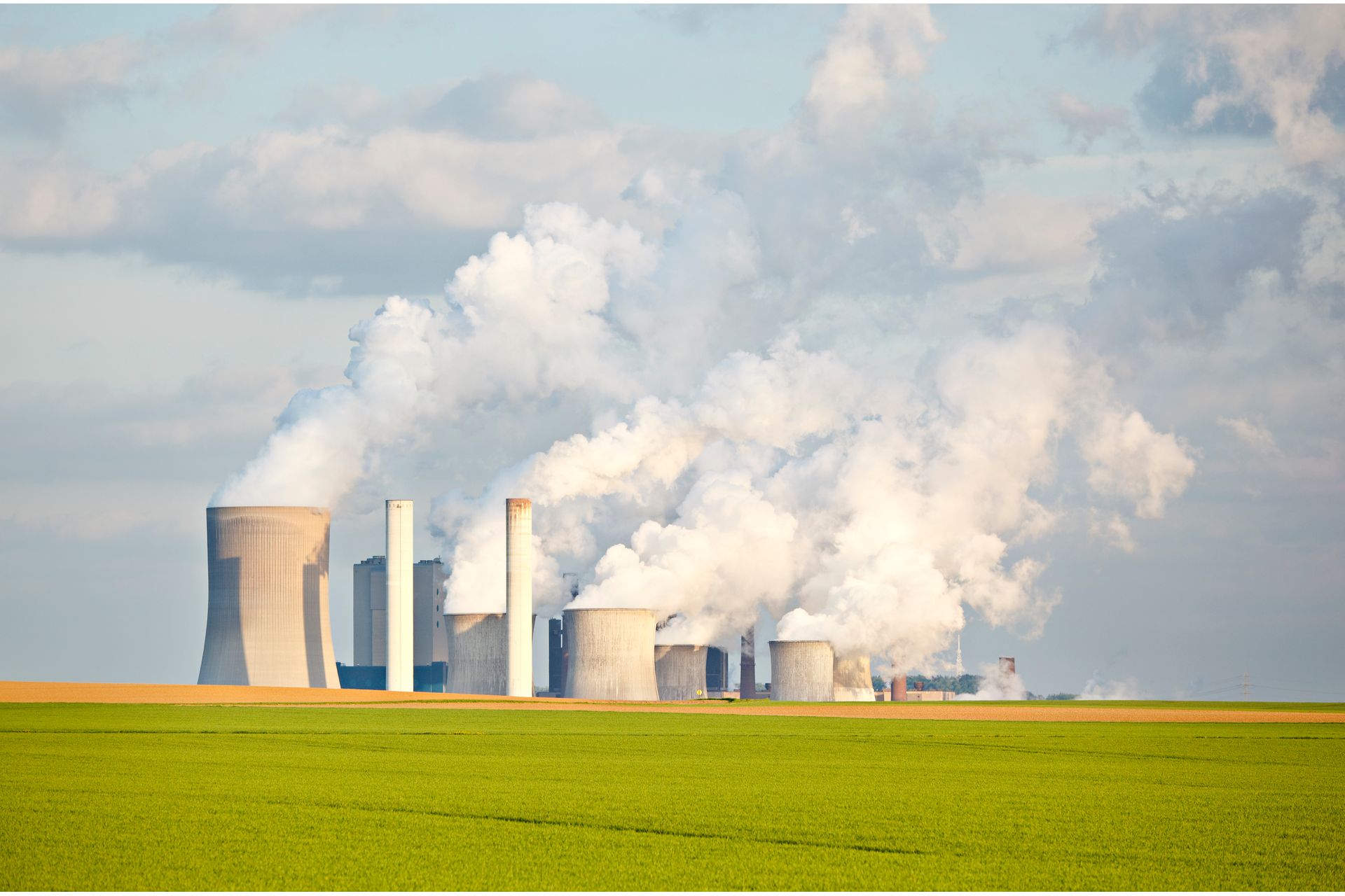 green-fields-in-front-of-industry-skyline-2023-11-27-05-18-56-utc--1-