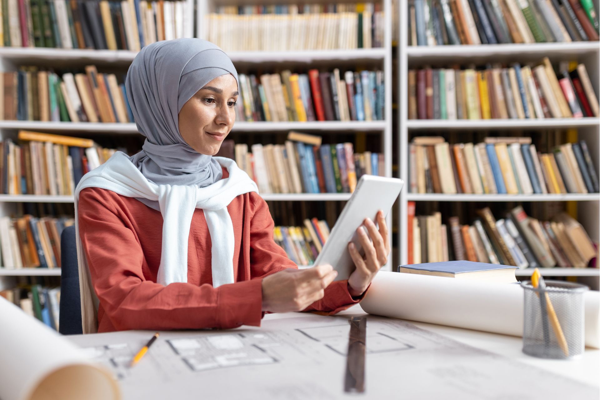 muslim-woman-using-tablet-in-library-with-architec-2024-04-10-16-40-24-utc--1-