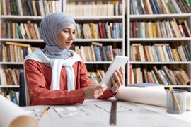 muslim-woman-using-tablet-in-library-with-architec-2024-04-10-16-40-24-utc--1-